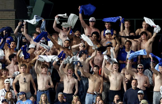 Chicago Cubs fans in the left field bleachers try to rally their team by taking off their shirts and waving them in the air in the ninth inning of a game against the Athletics at Wrigley Field in Chicago on June 2, 2026. (Chris Sweda/Chicago Tribune)