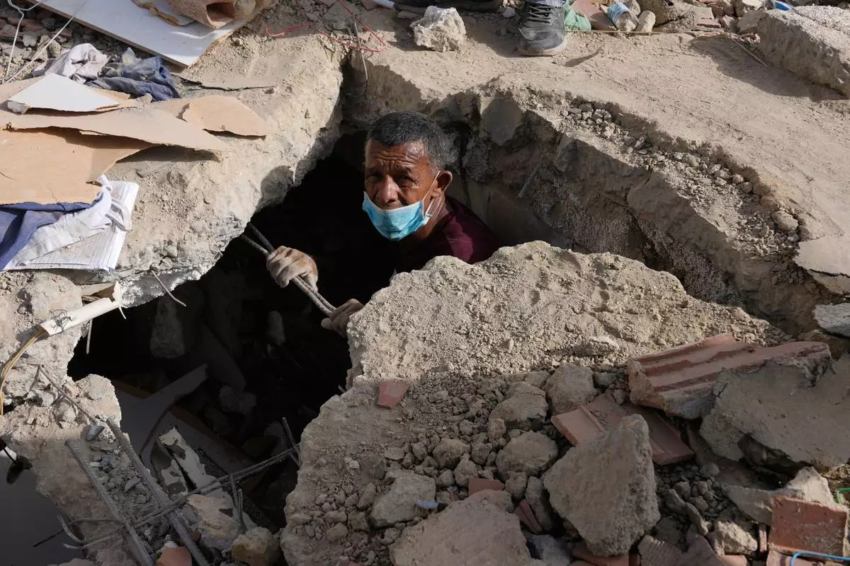 Franklin Fuentes searches for missing relatives in the collapsed building where they lived two days after earthquakes struck La Guaira, Venezuela, Friday, June 26, 2026. (AP Photo/Ariana Cubillos)