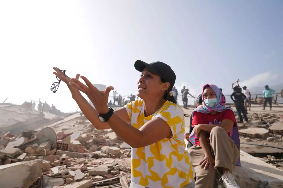 People search for missing relatives at the collapsed building where they lived two days after an earthquake struck La Guaira, Venezuela, Friday, June 26, 2026. (AP Photo/Ariana Cubillos)