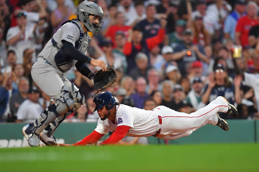 Boston Red Sox's Willson Contreras slides safely into home plate as New York Yankees catcher Austin Wells reaches for the ball.