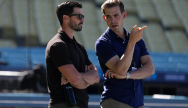 Jun 16, 2026; Los Angeles, California, USA; Los Angeles Dodgers general manager Brandon Gomes (left) talks with Spectrum SportsNet LA play-by-play announcer Joe Davis before the game against the Tampa Bay Rays at Dodger Stadium. Mandatory Credit: Kirby Lee-Imagn Images