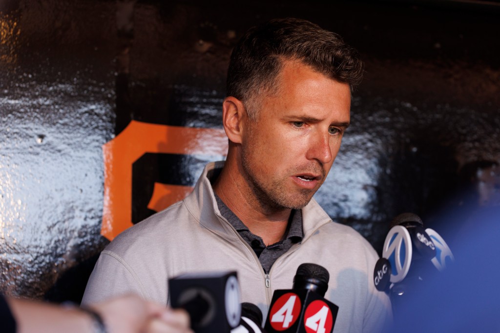 Buster Posey, president of operations for the San Francisco Giants, making a statement to microphones.
