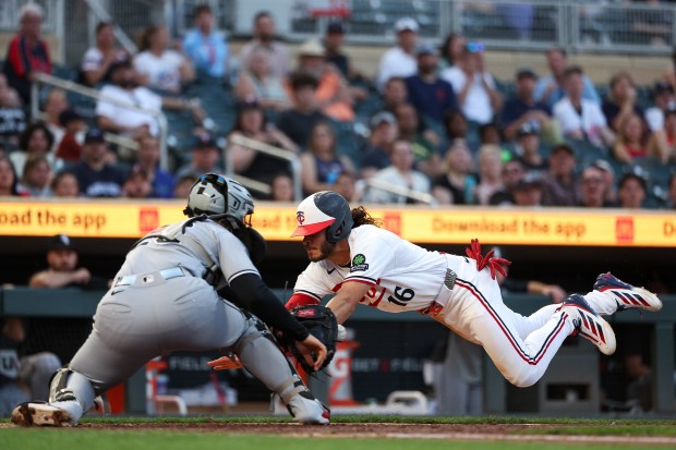 Minnesota Twins' Austin Martin slides safely into home plate as Chicago White Sox catcher Edgar Quero attempts a tag during the fifth inning of a baseball game, Monday, June 1, 2026, in Minneapolis. (AP Photo/Matt Krohn)