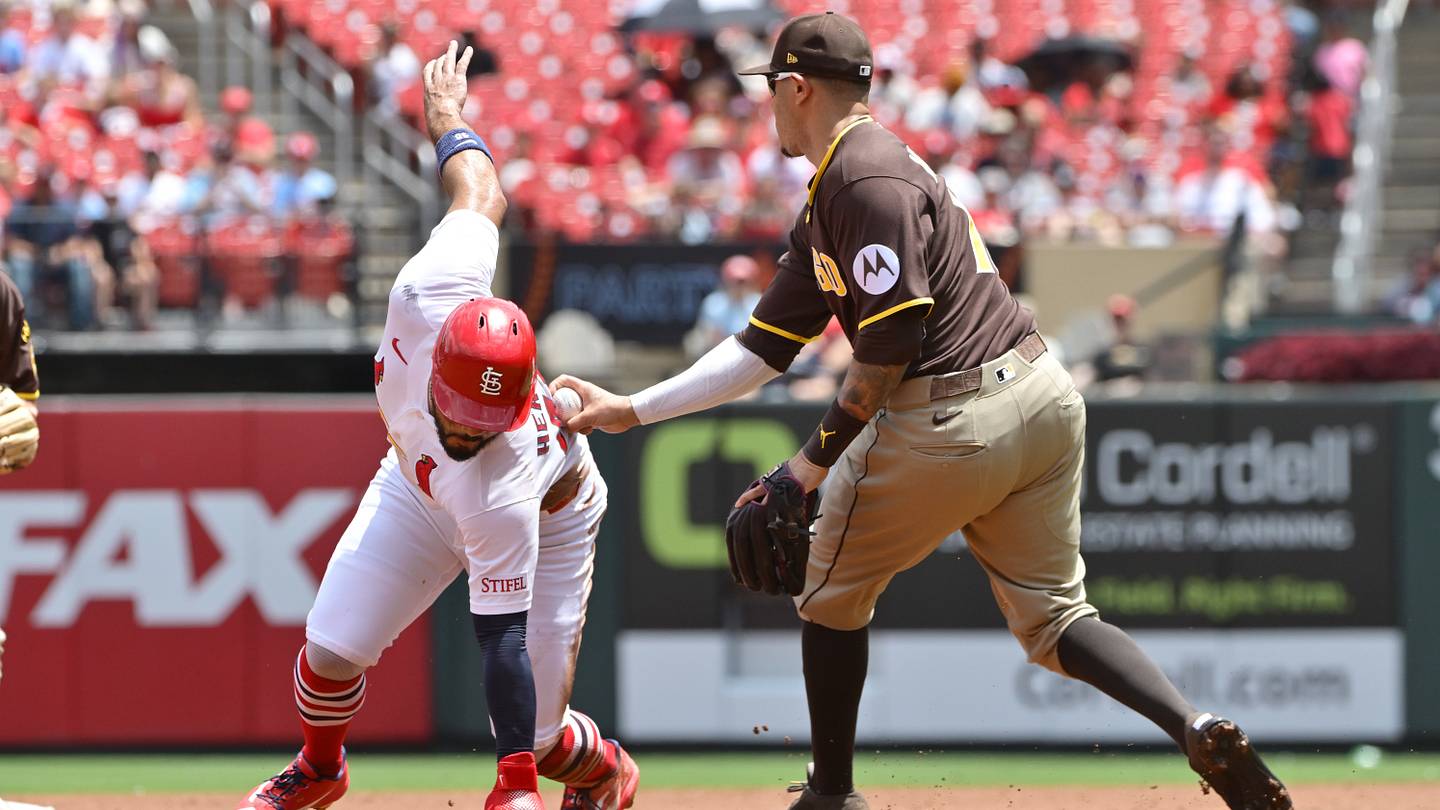 Jun 17, 2026; St. Louis, Missouri, USA; St. Louis Cardinals designated hitter Iván Herrera (48) is tagged out by San Diego Padres third baseman Manny Machado (13)after being caught in a rundown between second and third base in the first inning at Busch Stadium. Mandatory Credit: Tim Vizer-Imagn Images