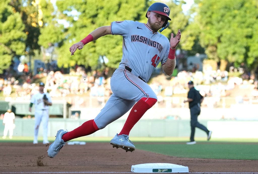 Washington Nationals player Curtis Mead running around third base to score a run.