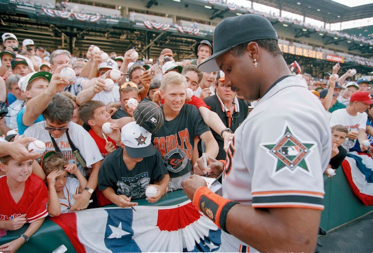 Fans standing several rows deep try for  an autograph from san Francisco Giants outfielder Barry Bonds before the 1993 All-Star Game in Baltimore.
