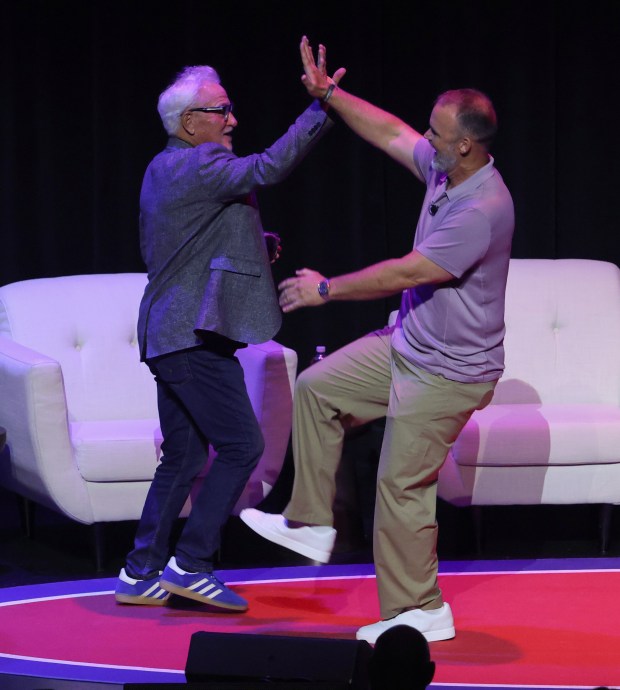 Former Cubs manager Joe Maddon, left, and former manager and catcher David Ross high-five each other while being introduced for "The Lovable Reunion Live" on July 16, 2026, at the Chicago Theatre. (John J. Kim/Chicago Tribune)
