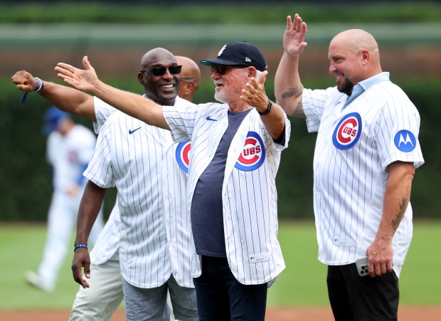 Former manager Joe Maddon gestures toward the Cubs dugout as the 2016 World Series championship team is honored before a game against the Twins on July 18, 2026, at Wrigley Field. (Chris Sweda/Chicago Tribune)