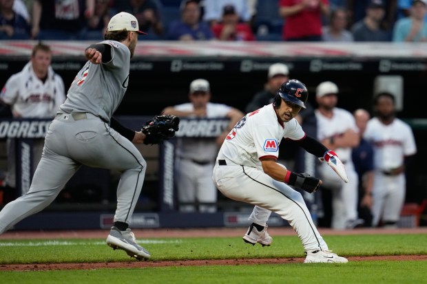 White Sox starter Sean Burke, left, tags out the Guardians' Steven Kwan during a rundown between third base and the plate in the fifth inning Saturday, July 4, 2026, in Cleveland. (Sue Ogrocki/AP)