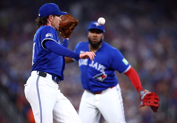 TORONTO, ON - JULY 18: Vladimir Guerrero Jr. #27 of the Toronto Blue Jays flips the ball to Shane Bieber #57 to get Kyle Teel #8 of the Chicago White Sox out (not pictured) in the first inning during the game at Rogers Centre on July 18, 2026 in Toronto, Ontario, Canada. (Photo by Vaughn Ridley/Getty Images)
