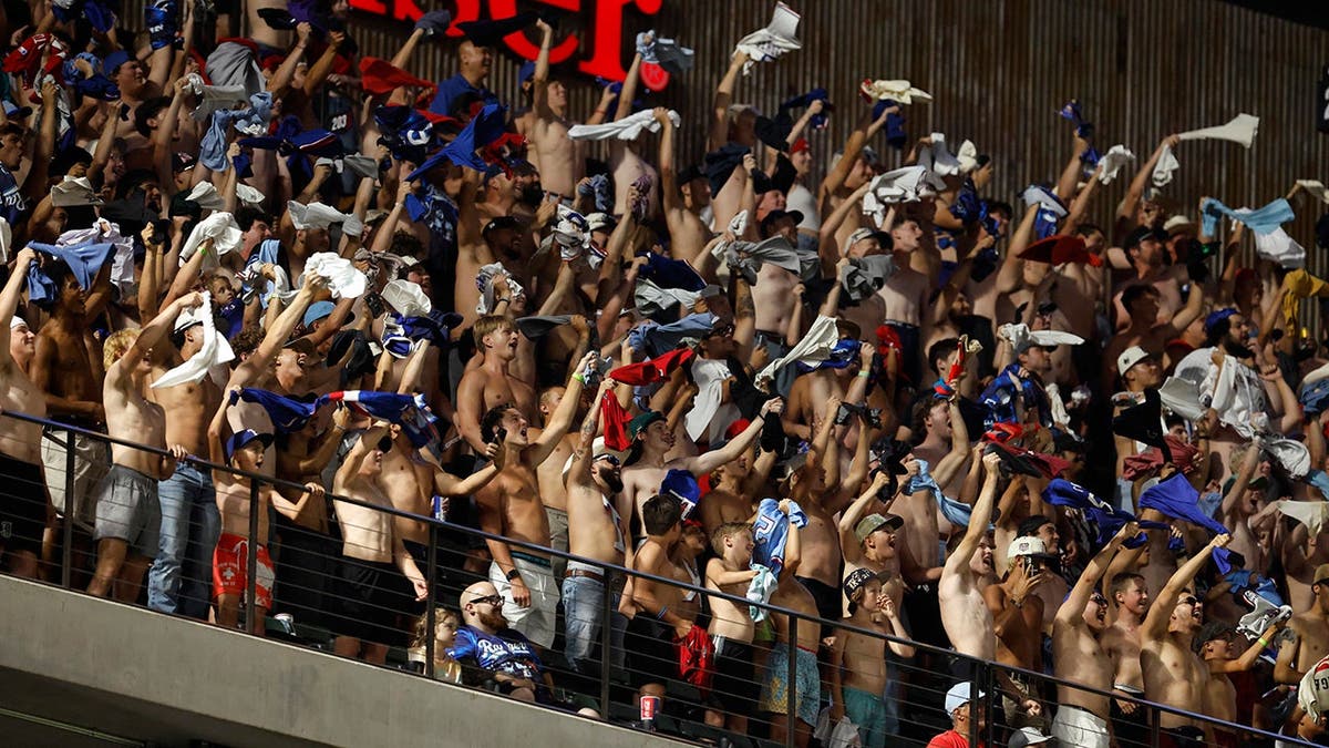 Shirtless fans cheer during a baseball game at Globe Life Field.