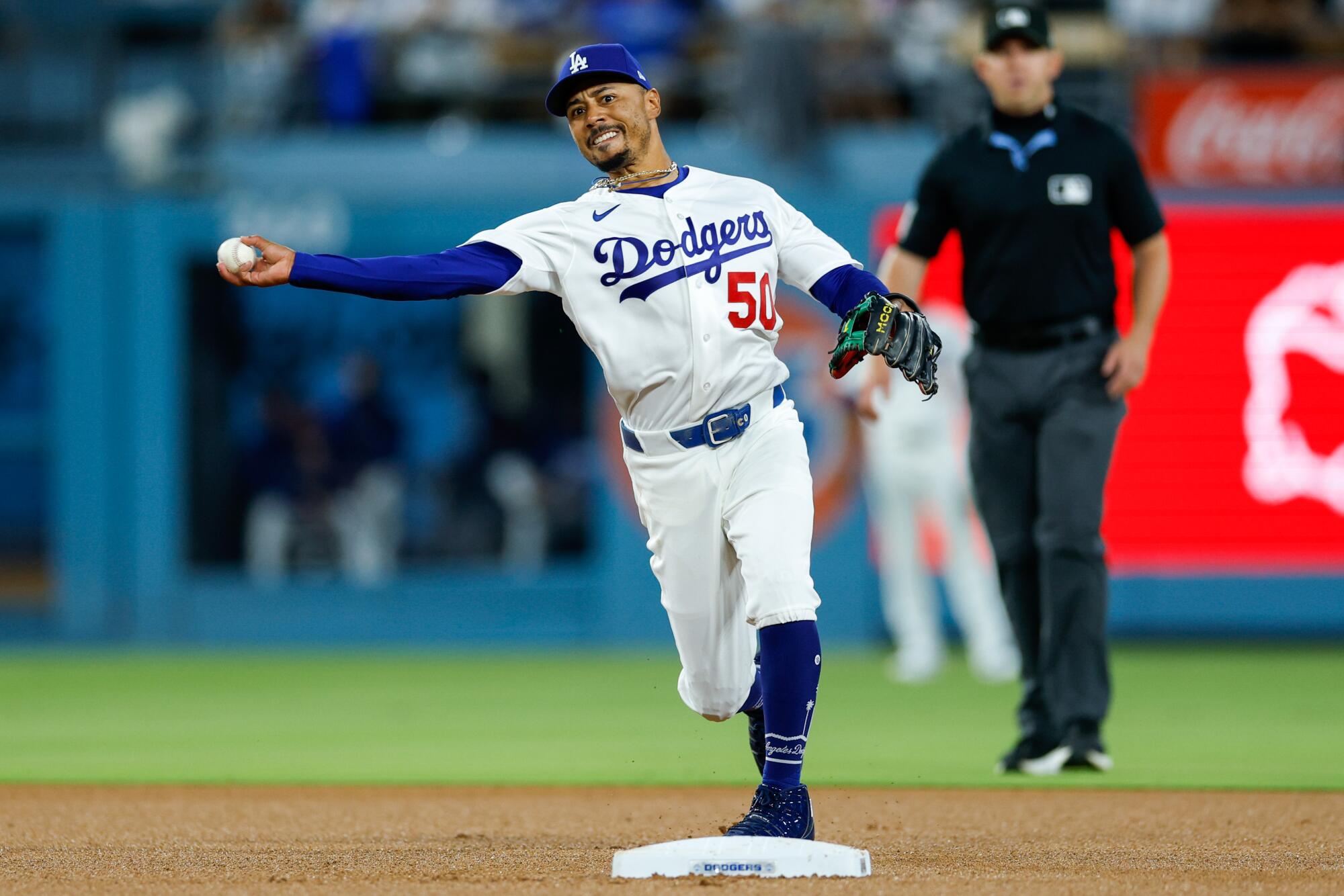 Dodgers shortstop Mookie Betts throws the ball across the infield to first base for an out against the Royals on Wednesday.