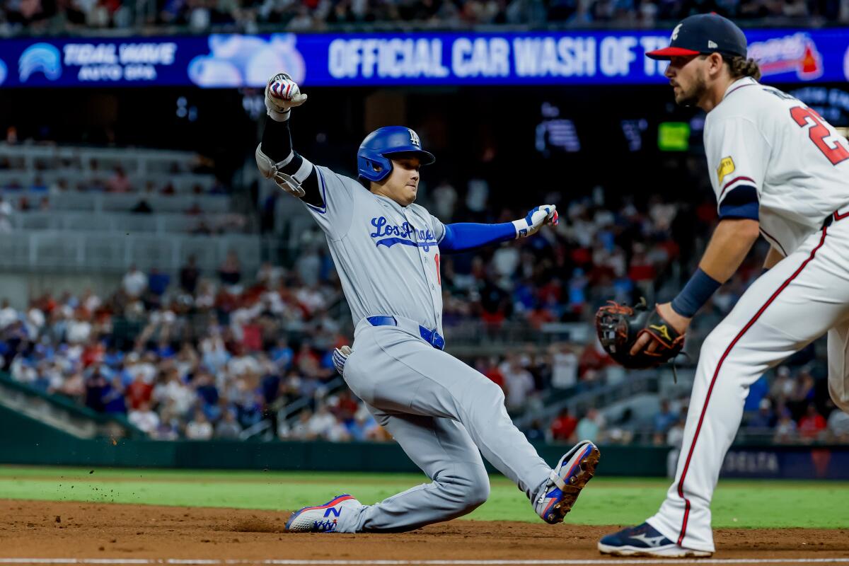 Shohei Ohtani slides into third for a triple to lead off the ninth inning Tuesday.