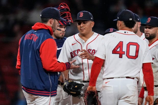 Boston Red Sox pitcher Ranger Suarez, center, heads to the dugout while being pulled by interim manager Chad Tracy, left, during the sixth inning of a baseball game against the Philadelphia Phillies, Thursday, May 14, 2026, in Boston. (AP Photo/Charles Krupa)