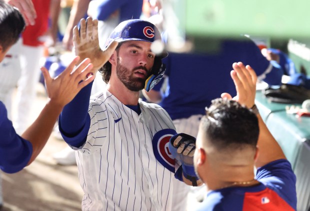 Chicago Cubs shortstop Dansby Swanson (7) is congratulated in the dugout after scoring on a single by teammate Pete Crow-Armstrong in the seventh inning of a game against the Los Angeles Dodgers at Wrigley Field in Chicago on Aug. 4, 2026. (Chris Sweda/Chicago Tribune)