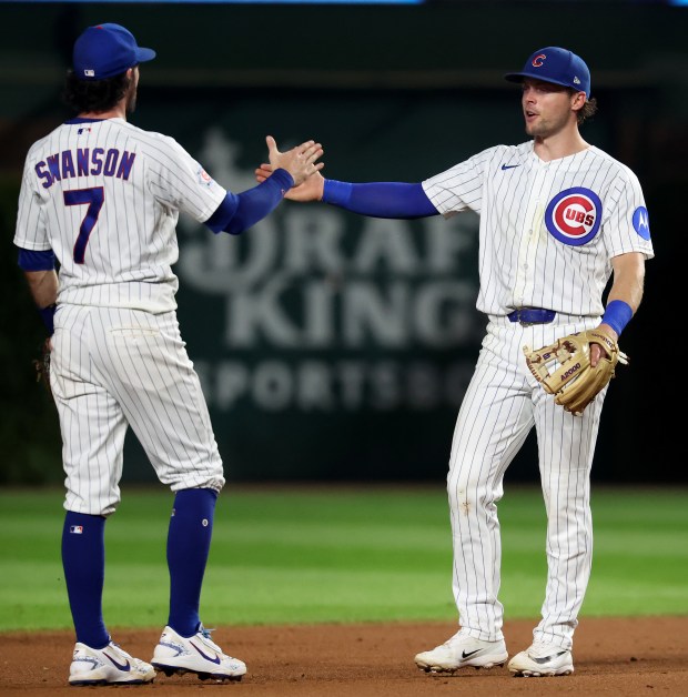 Chicago Cubs shortstop Dansby Swanson (7) and second baseman Nico Hoerner celebrate after their victory over the Los Angeles Dodgers at Wrigley Field in Chicago on Aug. 4, 2026. (Chris Sweda/Chicago Tribune)