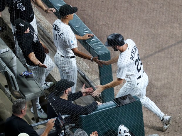 Chicago White Sox left fielder Tristan Peters (29) is congratulated by manager Will Venable (1) after Peters scored on a single by teammate Miguel Vargas in the fourth inning of a game against the Texas Rangers at Rate Field in Chicago on Aug. 26, 2026. (Chris Sweda/Chicago Tribune)