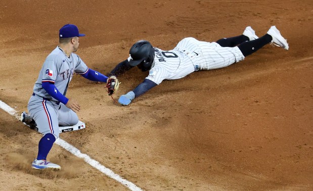 Texas Rangers third baseman Cody Freeman tags out Chicago White Sox shortstop Luisangel Acuña at third base on a steal attempt in the fourth inning of a game at Rate Field in Chicago on Aug. 26, 2026. (Chris Sweda/Chicago Tribune)