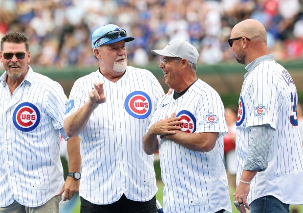 Greg Maddux, center right, gets comments from fellow former Cubs pitchers after throwing a ceremonial first pitch out of the strike zone before a Cubs-Reds game at Wrigley Field on Aug. 29, 2026, in Chicago. (John J. Kim/Chicago Tribune)