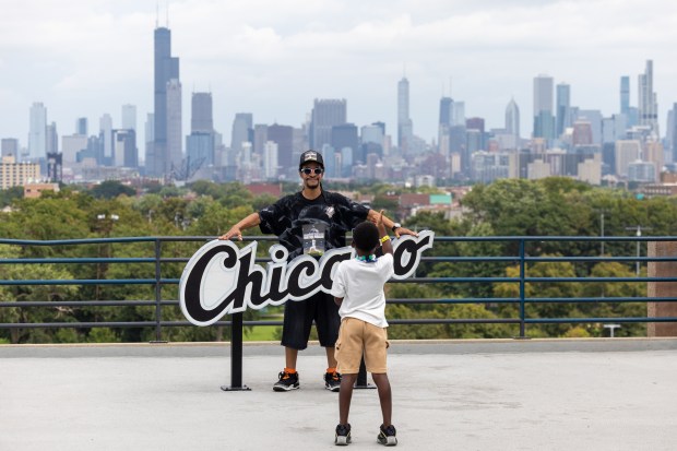 Omarion Carter, 9, takes a picture of his grandfather, Christopher Johnson before a baseball game between the Cleveland Guardians and Chicago White Sox at Rate Field in Chicago, Sunday, Aug. 9, 2026. (Arthur Maiorella/Chicago Tribune)