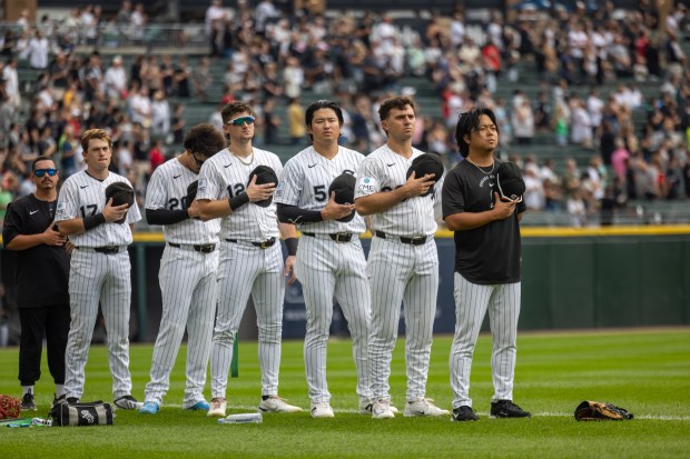 Members of the Chicago White Sox listen to "America the Beautiful" and "The Star Spangled Banner" before a baseball game between the Cleveland Guardians and Chicago White Sox at Rate Field in Chicago, Sunday, Aug. 9, 2026. (Arthur Maiorella/Chicago Tribune)