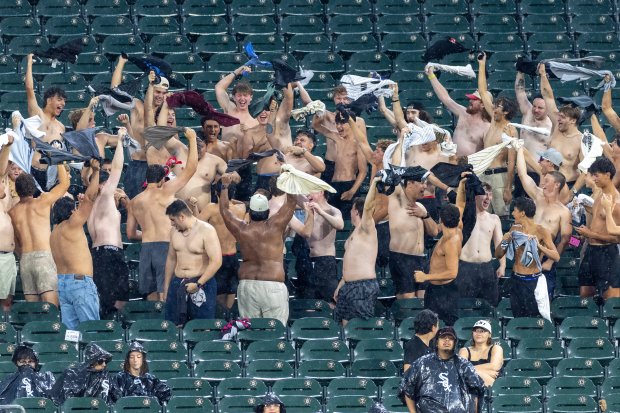 Shirtless fans react to a rain delay during the second inning of a baseball game between the Cleveland Guardians and Chicago White Sox at Rate Field in Chicago, Sunday, Aug. 9, 2026. (Arthur Maiorella/Chicago Tribune)