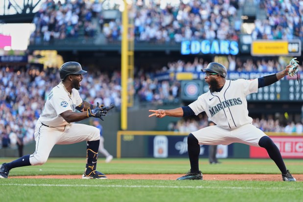 Mariners left fielder Randy Arozarena, left, gestures with first-base coach Eric Young Jr. after hitting a two-run walk-off home run in the ninth inning against the Cubs on Saturday, Aug. 22, 2026, in Seattle. (Lindsey Wasson/AP)
