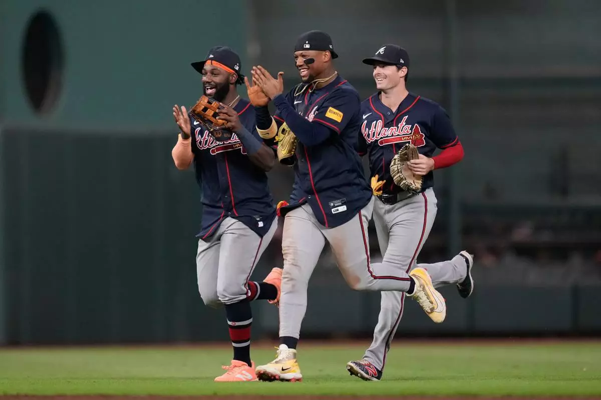 Atlanta Braves center fielder Michael Harris II, left, right fielder Ronald Acuña Jr., center, and left fielder Mike Yastrzemski celebrate after winning a baseball game against the Houston Astros in Houston, Saturday, Sept. 19, 2026. (AP Photo/Ashley Landis)