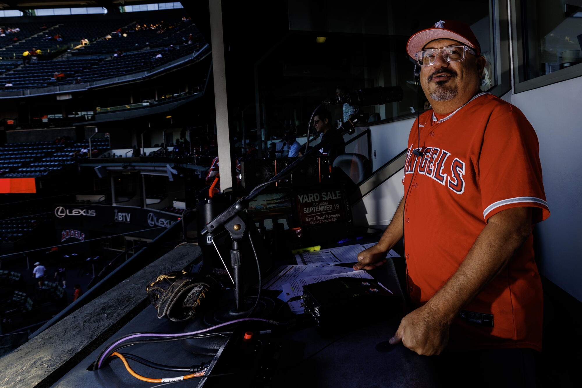Angels public address announcer Michael Araujo overlooks the field in his booth before a game.