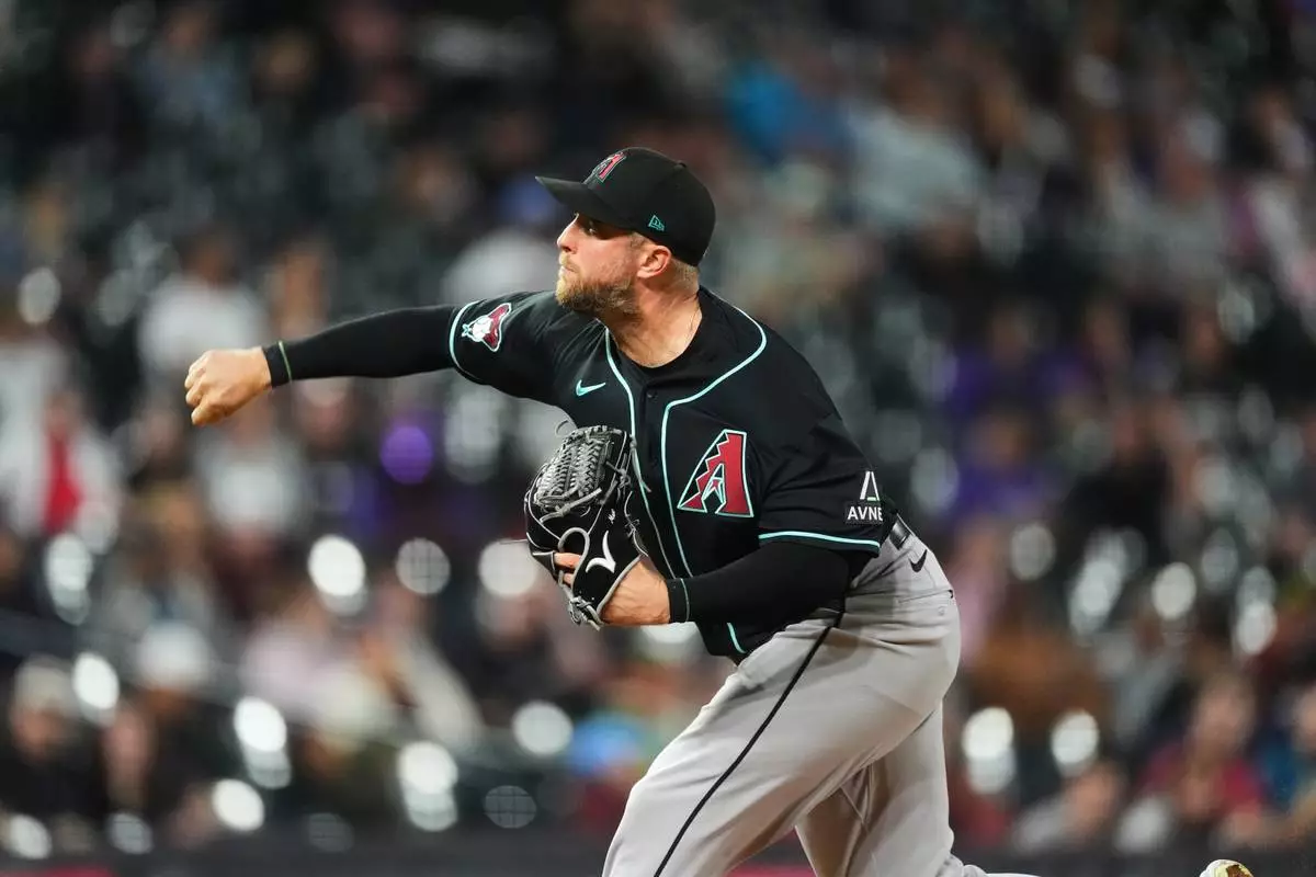 Arizona Diamondbacks starting pitcher Merrill Kelly works against the Colorado Rockies in the second inning of a baseball game Wednesday, Sept. 23, 2026, in Denver. (AP Photo/David Zalubowski)