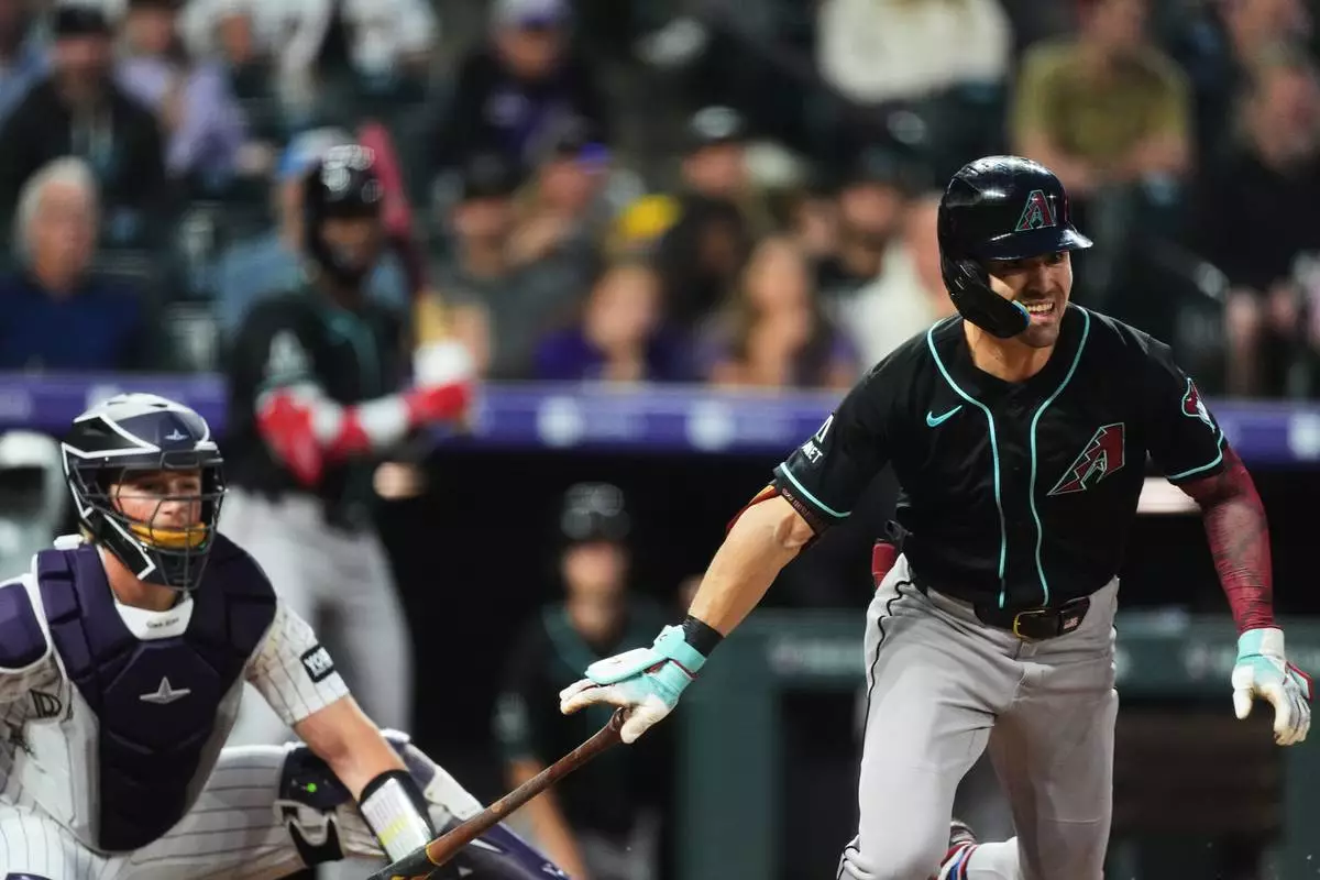 Arizona Diamondbacks' Corbin Carroll, right, breaks from the batter's box after connecting for a triple to drive in two runs as Colorado Rockies catcher Hunter Goodman looks on in the first inning of a baseball game Wednesday, Sept. 23, 2026, in Denver. (AP Photo/David Zalubowski)