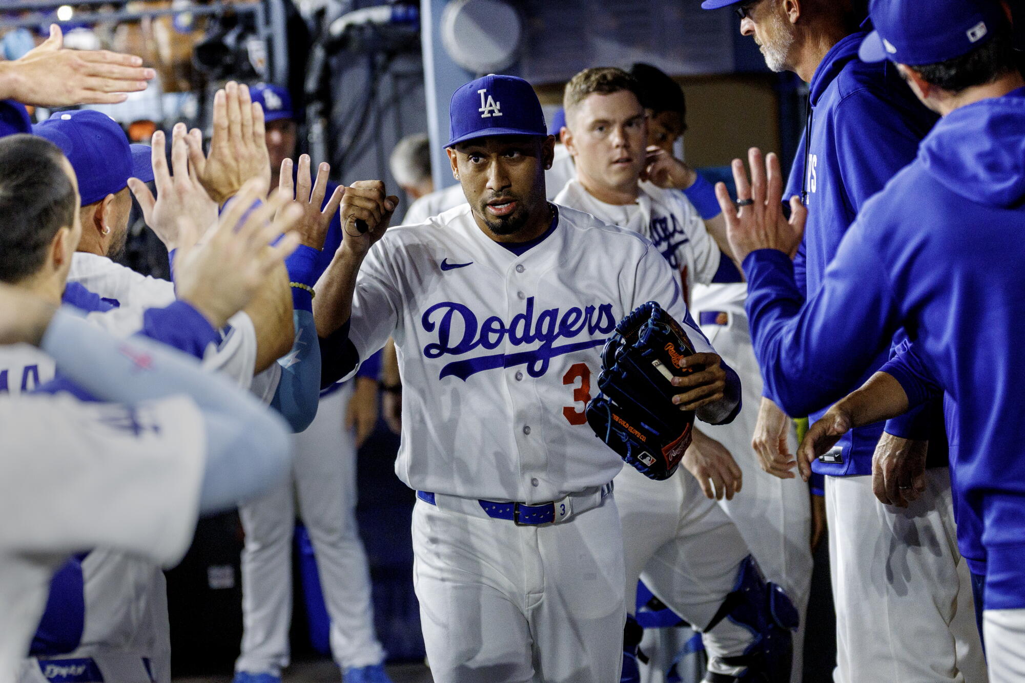 Dodgers reliever Edwin Díaz high-fives teammates in the dugout after pitching against the San Diego Padres.