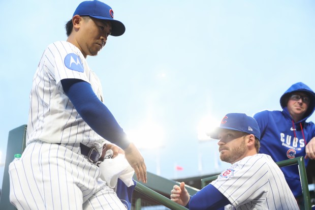 Cubs starting pitcher Shota Imanaga, left, enters the dugout before a game against the Marlins at Wrigley Field on Sept. 22, 2026, in Chicago. (John J. Kim/Chicago Tribune)