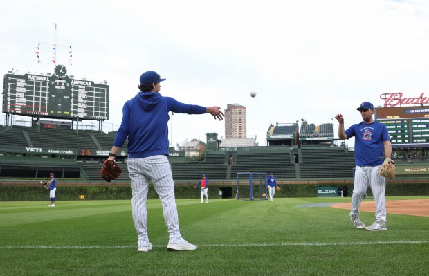 Cubs third baseman Alex Bregman, right, tosses a ball with hitting development coach Ben Martin before a game against the Marlins at Wrigley Field on Sept. 22, 2026, in Chicago. Bregman was injured in the face by a foul ball on Sept. 20. (John J. Kim/Chicago Tribune)