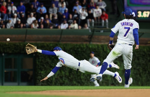 Cubs second baseman Nico Hoerner dives for a ball hit by Marlins shortstop Otto Lopez for a single in the 11th inning at Wrigley Field on Sept. 22, 2026, in Chicago. (John J. Kim/Chicago Tribune)