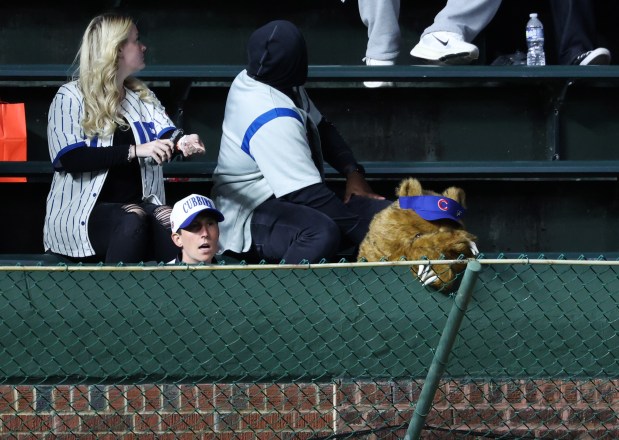A Cubs fan in costume rests her head in the left-field bleachers in the middle of the 12th inning of a Cubs-Marlins game at Wrigley Field on Sept. 22, 2026, in Chicago. Cubs pitchers gave up six runs in the inning. (John J. Kim/Chicago Tribune)