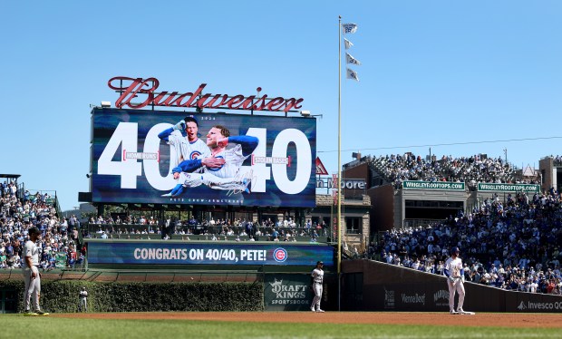 The Cubs display a "40-40" graphic on the left-field video board as center fielder Pete Crow-Armstrong stands on second base after a steal in the first inning against the Marlins on Thursday, Sept. 24, 2026, at Wrigley Field. Crow-Armstrong became the seventh player in MLB history to reach 40 home runs and 40 stolen bases in a season. (Chris Sweda/Chicago Tribune)