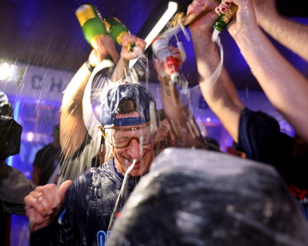 Manager Craig Counsell is doused with Champagne in the clubhouse after the Cubs clinched a playoff spot Thursday, Sept. 24, 2026, at Wrigley Field. (Chris Sweda/Chicago Tribune)