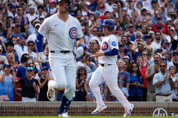 Cubs third baseman Alex Bregman, right, scores as Nico Hoerner walks to first after being hit by a pitch against the Pirates in the eighth inning Saturday, Sept. 12, 2026, at Wrigley Field. (Nam Y. Huh/AP)