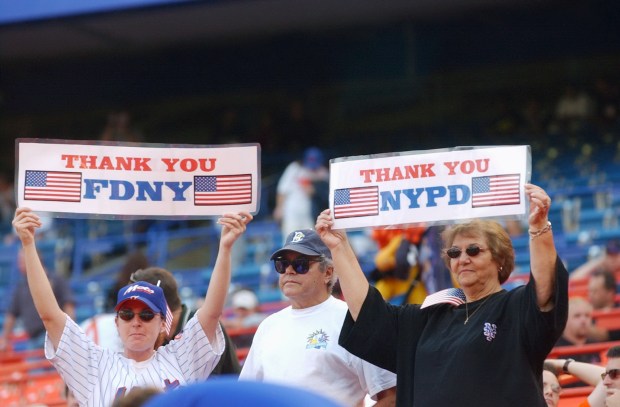 Spectators at Shea Stadium hold up placards thanking New York City's Fire and Police Departments for their work at the site of the World Trade Center site on Sep. 21, 2001.