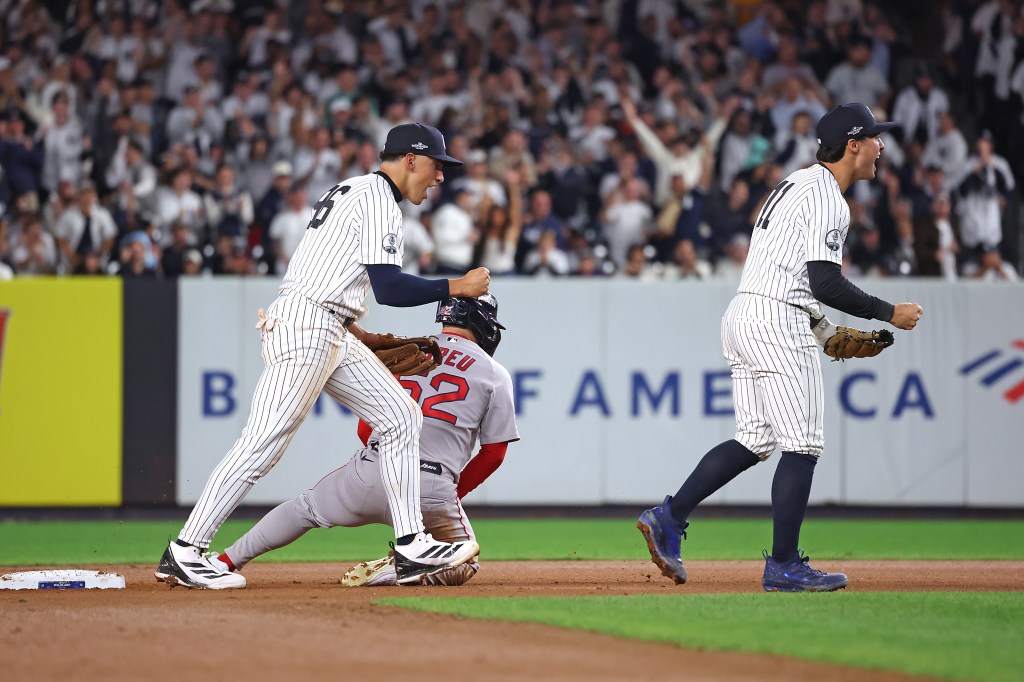 New York Yankees shortstops George Lombard Jr. and Anthony Volpe celebrate after completing a double play against the Boston Red Sox.