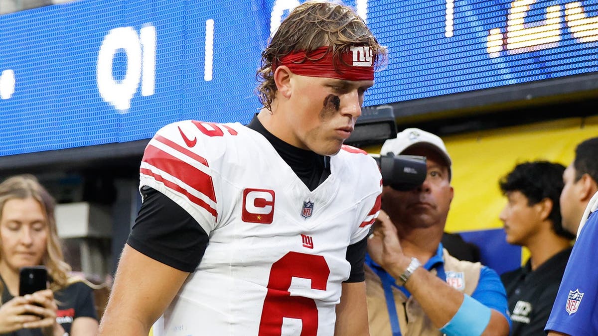 Jaxson Dart walks off the field with an injury during an NFL game between the Giants and Rams.