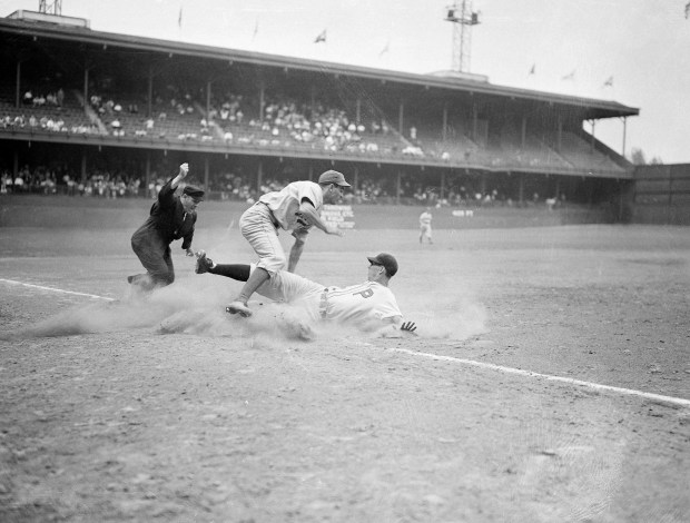 Stan Benjamin, Phillies outfielder, is out at third in the fifth inning of the nightcap game in the doubleheader between the Brooklyn Dodgers and the Phils at Philadelphia, Sept. 3, 1941. Benjamin was caught trying to stretch his drive to left field into a triple. Cookie Lavagetto, Dodgers third baseman, leaps high to avoid Benjamin's spikes as he makes the putout and umpire Bill Stewart calls the play. The Phillies won, 4-1. (AP Photo)