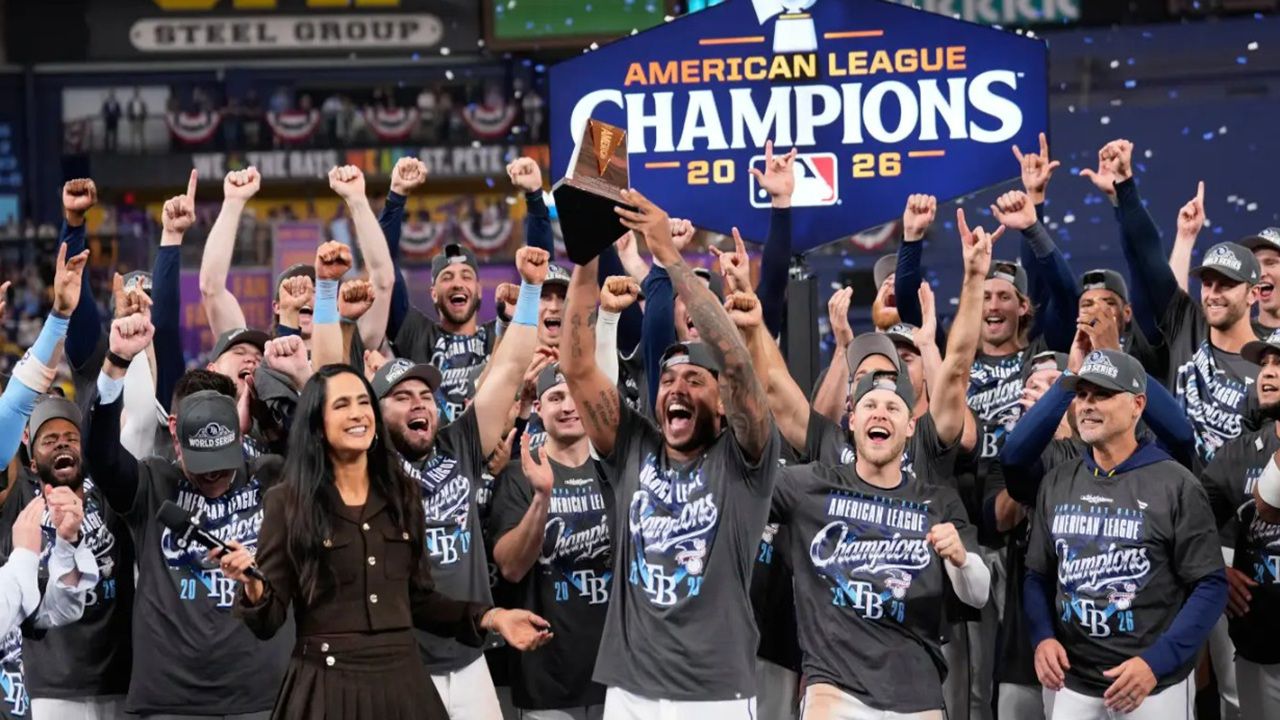 Rays pitcher Freddy Peralta (center) holds the ALCS MVP trophy after Tampa Bay's 7-3 win against Ckeveland in Game 6 Monday night at Tropicana Field in St. Petersburg. (AP Photo/David J. Phillip)