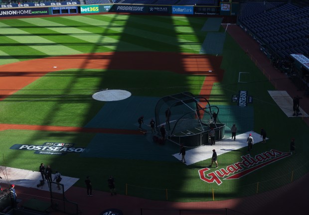 Grounds crew workers prepare for batting practice before Game 1 of the AL Division Series between the White Sox and Guardians on Oct. 3, 2026, in Cleveland. (John J. Kim/Chicago Tribune)