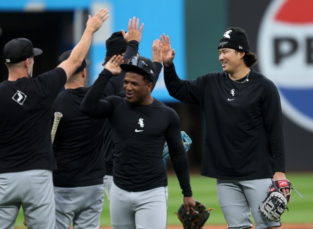 White Sox first baseman Munetaka Murakami, right,high-fives teammates while taking fielding practice ahead of Game 5 of the ALDS in Cleveland on Oct. 10, 2026. (Chris Sweda/Chicago Tribune)