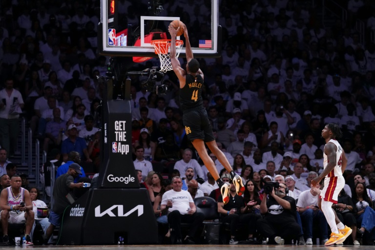 Evan Mobley of the Cleveland Cavaliers dunks the ball against Davion Mitchell in the Cavs