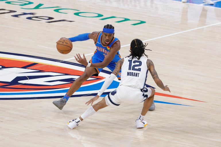 Apr 22, 2025; Oklahoma City, Oklahoma, USA; Oklahoma City Thunder guard Shai Gilgeous-Alexander (2) moves the ball against Memphis Grizzlies guard Ja Morant (12) in the fourth quarter during game two of first round for the 2024 NBA Playoffs at Paycom Center. Mandatory Credit: Alonzo Adams-Imagn Images