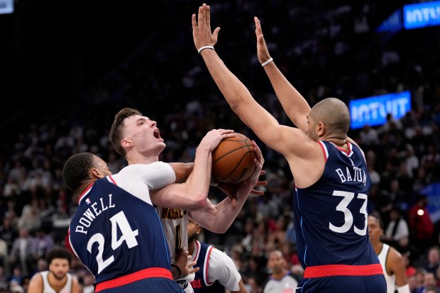 Denver Nuggets guard Christian Braun, center, tries to shoot as Los Angeles Clippers guard Norman Powell, left, and forward Nicolas Batum defend during the second half in Game 3 of an NBA basketball first-round playoff series Thursday, April 24, 2025, in Inglewood, Calif. (AP Photo/Mark J. Terrill)