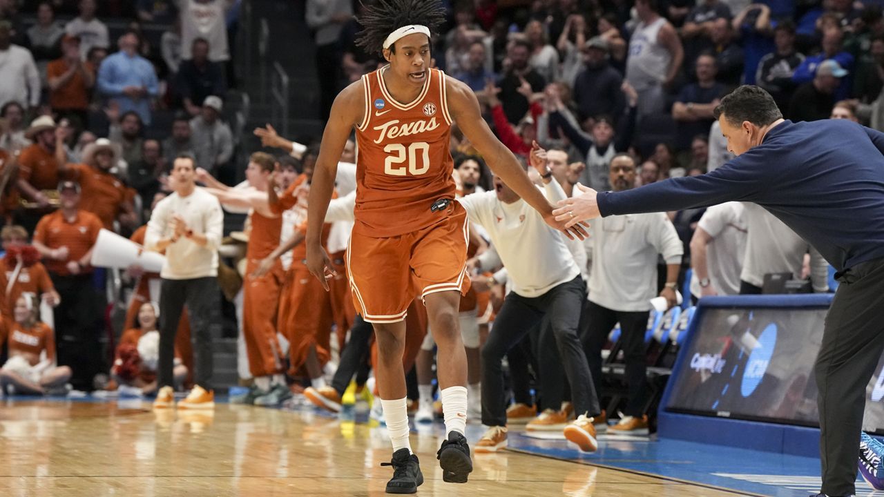 Texas guard Tre Johnson (20) celebrates with Xavier head coach Sean Miller after scoring during the second half of a First Four college basketball game in the NCAA Tournament, Wednesday, March 19, 2025, in Dayton, Ohio. (AP Photo/Jeff Dean)